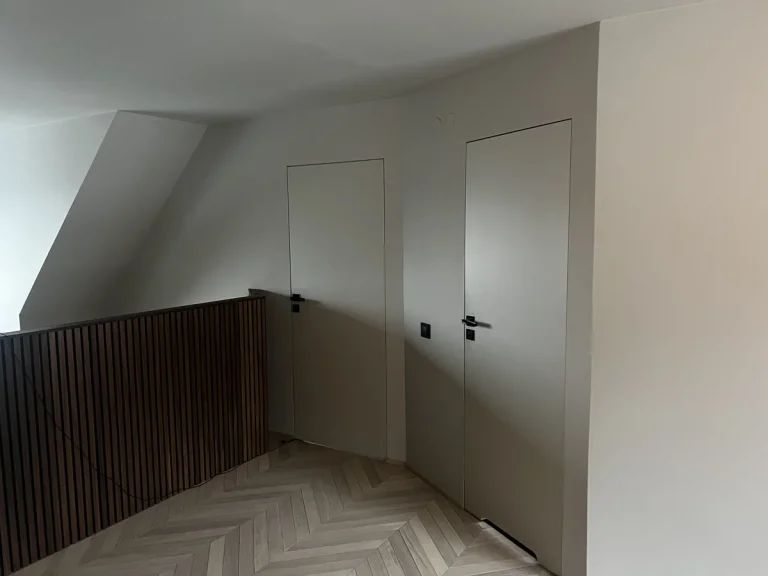 Två innerdörrar i liv med väggen intill en träbalustrad